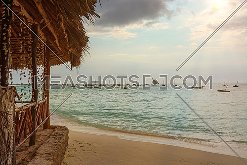 A wonderful beach with Several fishing boats anchored at sunset with sunbeams.Zanzibar coast,Tanzania.