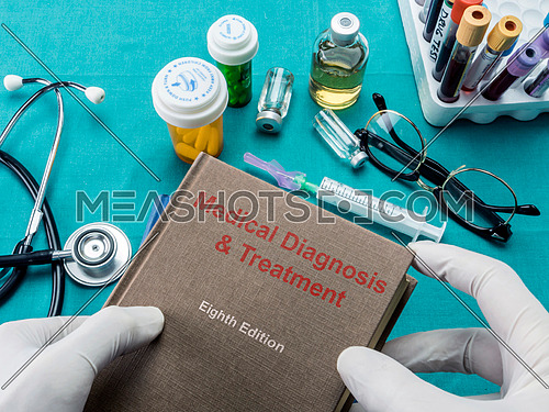 Doctor holds book of diagnosis and medical treatment, conceptual image