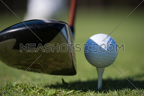 golf club and ball in grass on course preparing for shot