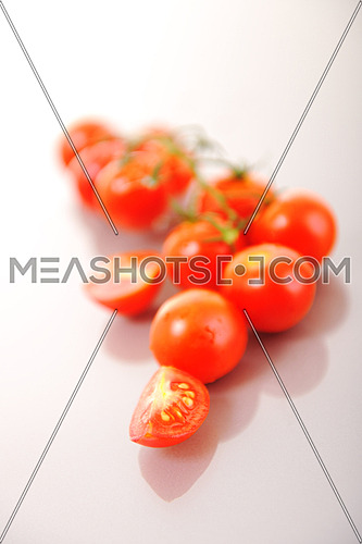 small wet fresh red tomato group isolated on white with glossy surface reflection