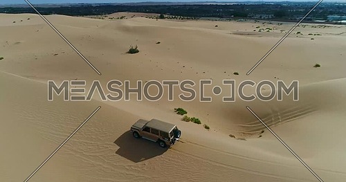 A car moving through sand dunes in the desert