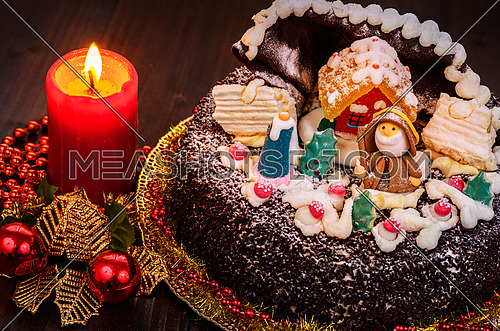 Chocolate cake decorated for christmas with candle  on wooden table.