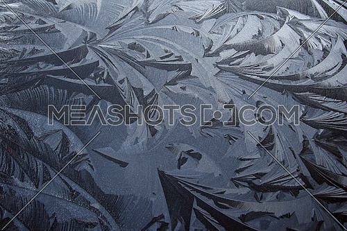 Amazing ice formation designing all kinds of shapes on a black car roof in the winter