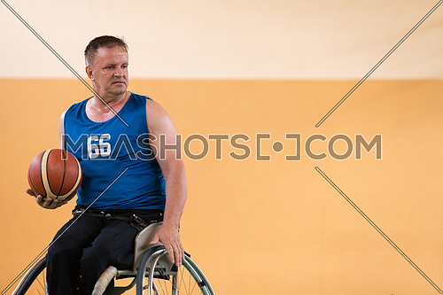 disabled war veterans in action while playing basketball on a basketball court with professional sports equipment for the disabled. High quality photo