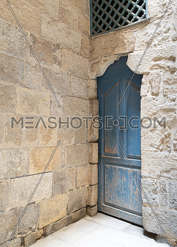 Vintage blue wooden closed door, wooden window with interleaved wooden grid (mashrabiya) and stone bricks wall, Medieval Cairo, Egypt