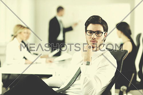 Portrait of a handsome young business man with people  in background at office meeting
