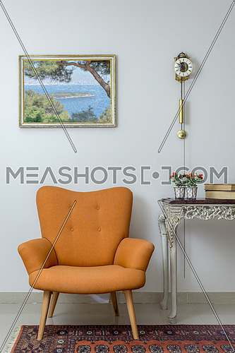 Vintage Furniture - Interior composition of retro orange armchair, vintage wooden beige table, and pendulum clock over off white wall, tiled beige floor and orange ornate carpet