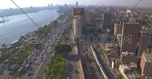 Reveal shot for the city beside the River Nile while Metro Passing by in Cairo at sunset