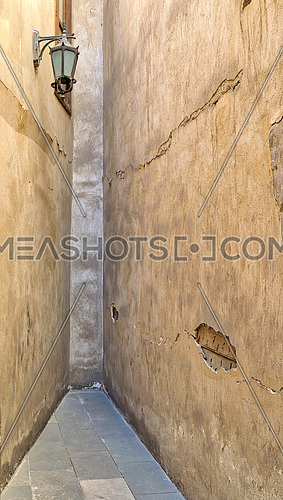 Dead end Narrowing isle with stone grunge walls and lantern at an old abandoned historic palace, Cairo, Egypt