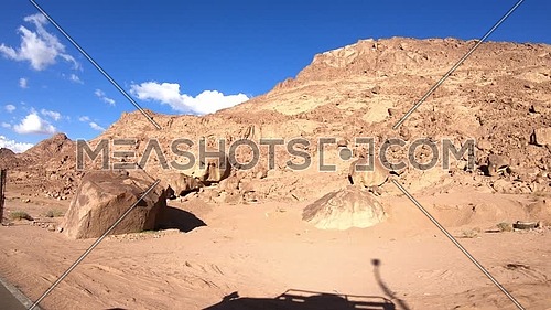 Follow shot for Sinai Mountain from a car driving on the route at day