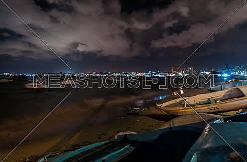 Track Right shot for sea shore showing fishing boats at alexandria at night