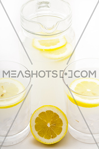 fresh lemonade drink with lemon slice closeup and pitcher carafe
