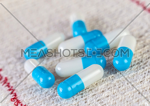 Some white and blue pills wrapped in gauze, conceptual image
