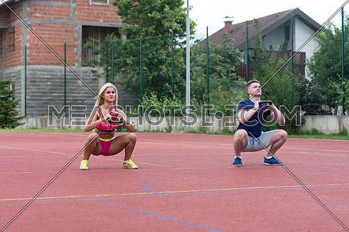A Group Of Young People In Aerobics Class Doing A Kettle Bell Exercise Outdoor