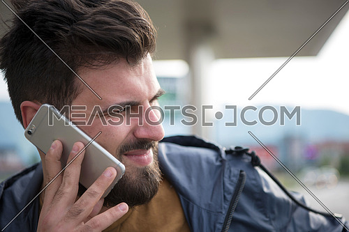 handsome young casual business man with beard using cell phone and smile outdoor on city street
