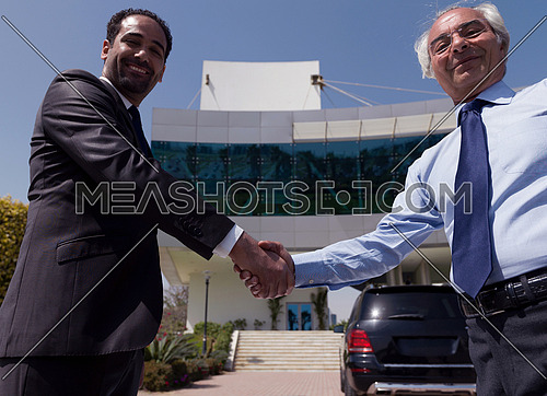 business people handshake and make deal  in front of modern corporate  building