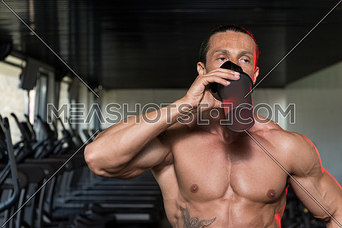 Muscular Mature Man Drinking A Water Bottle
