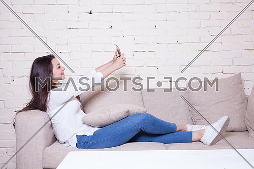 A girl sitting on a couch holding her mobile