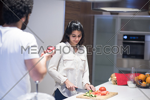 a young middle east couple preparing salad in the kitchen with satisfaction