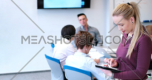 Business Woman Using Digital Tablet in Busy Office
