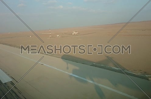 POV shot from plane front showing it's shadow landing at day