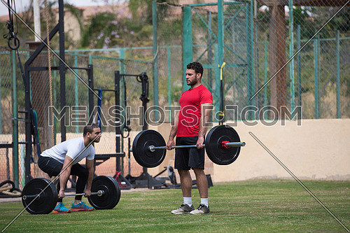Young middle eastern athletic people exercise weightlifting outside on a sunny day