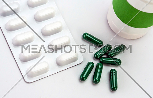 Some white and green capsules along with closed boat, conceptual image