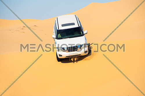 An SUV dune bashing in the desert