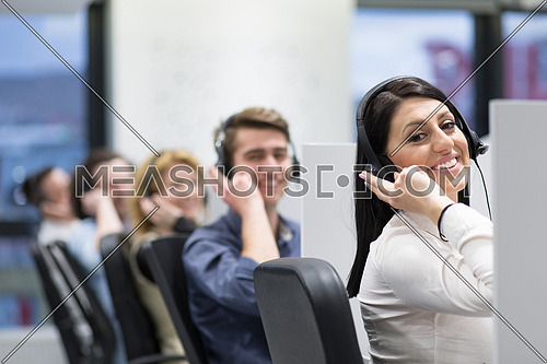 group of young business people with headset working and giving support to customers in a call center office