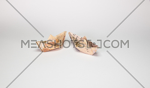 Two Egyptian Pound notes folded like paper boat floating concept