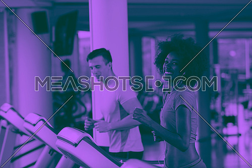 young people exercisinng a cardio on treadmill running machine in modern gym duo tone filter