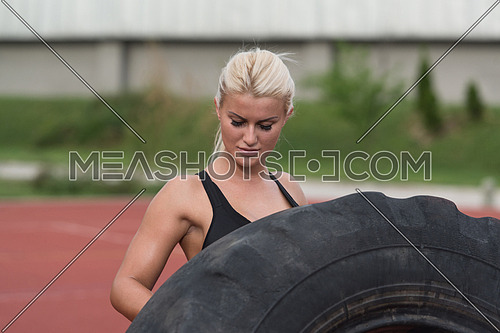 Young Woman Turning Tire Over - Bodybuilding Exercises Truck Tire
