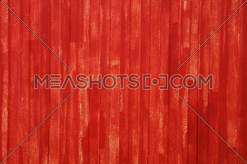 Abstract background texture of red painted vivid metal wall surface with uneven grunge paint strokes, close up