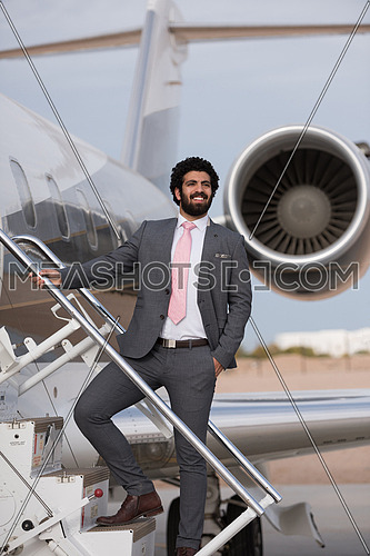 Portrait of a young middle eastern successful businessman at the airport entering the private plane