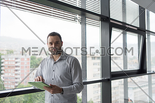 Businessman Using Digital Tablet in corporate office by window