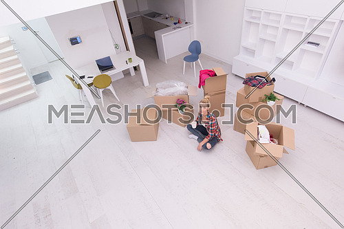 people, moving new place and repair concept   happy beautiful  young woman with many cardboard boxes sitting on floor with Cup at home