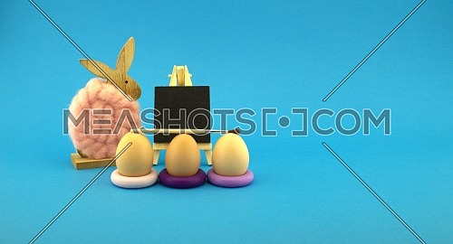 Cute colorful Easter still life or card design with three eggs in purple rings in front of a small blank blackboard with woolly rabbit alongside over a vivid blue background with copy space