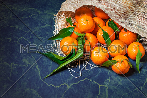 Fresh mandarins stacked on hessian sack