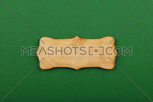 Figured ornately shaped blank wooden sign with copy space in center of green design paper background, title slide template
