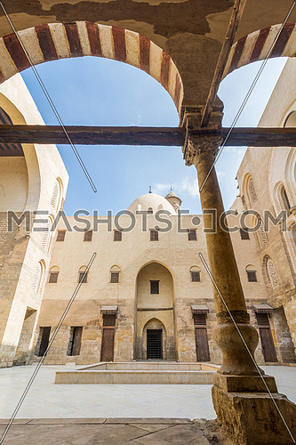 Facade of main courtyard of Mamluk era public historic mosque of Sultan Qalawun framed by stone arch, Moez Street, Gamalia District, Cairo, Egypt