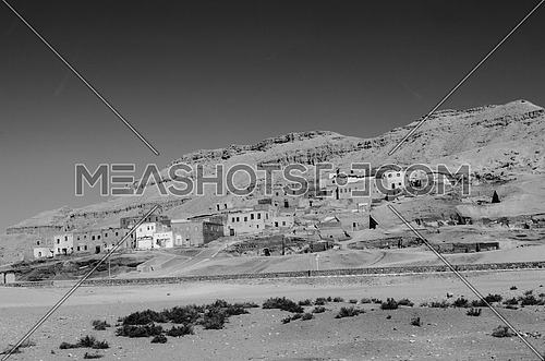 an old city build in between the mountains in black and white in Luxor city monochrome