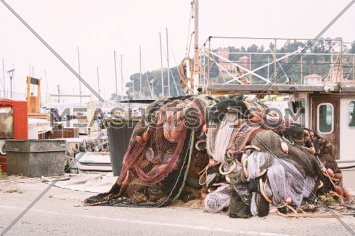 Fishing nets stacked on the waterfront after fishing day,quayside of the port of Varazze, Liguria Italy.