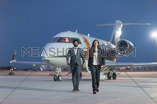 young successful middle eastern businessmen walking in front of private airplane