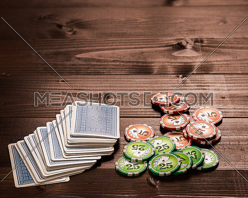 old vintage cards and a gambling chip on a wood table.
