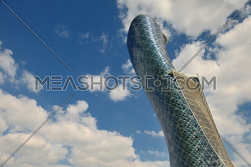 modern building of steel and glass facade with blue sky and clouds in background