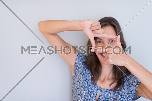 young happy woman showing framing hand gesture isolated on a white background