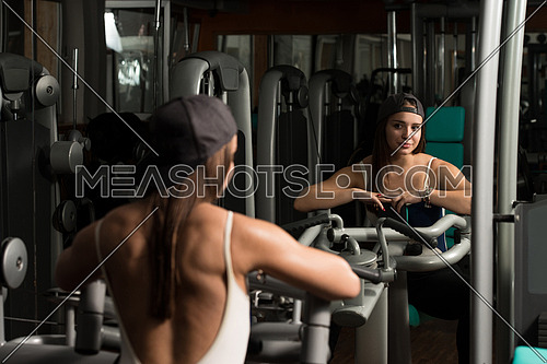 Young Woman Doing Heavy Weight Exercise For Back In Gym