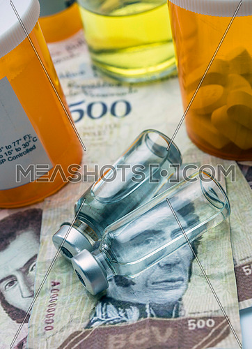 Vials with medication on banknotes Bolivarian, shady deal of medicines in full crisis of Latin American country, conceptual image