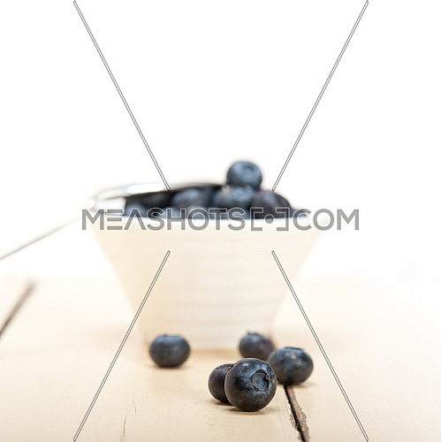 fresh blueberry on a bowl with silver spoon over wood table