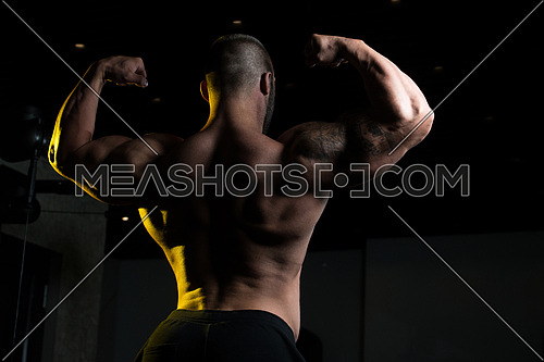 Man Standing Strong In The Gym And Flexing Muscles - Muscular Athletic Bodybuilder Fitness Model Posing After Exercises